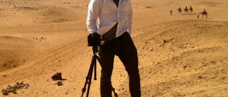 Casey Neistat Rocks the Oscars Self-portrait of Casey Neistat standing in front of a camera on a tripod atop a sand dune in the desert with camels in the background. Apparently taken during filming "Make It Count" for Nike.
